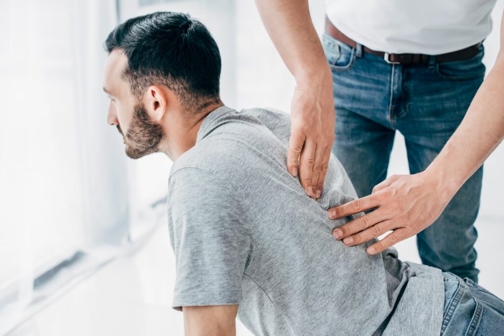 chiropractor massaging back of bearded man in hosp 2024 11 18 18 58 12 utc