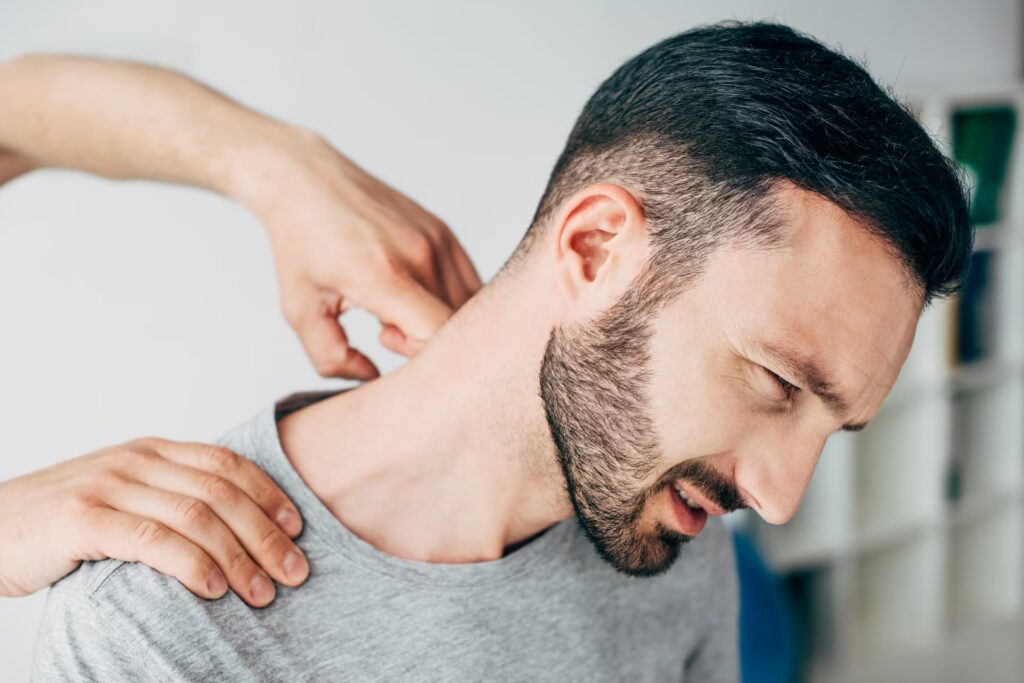 chiropractor massaging neck of bearded man in hosp 2024 11 15 15 01 34 utc
